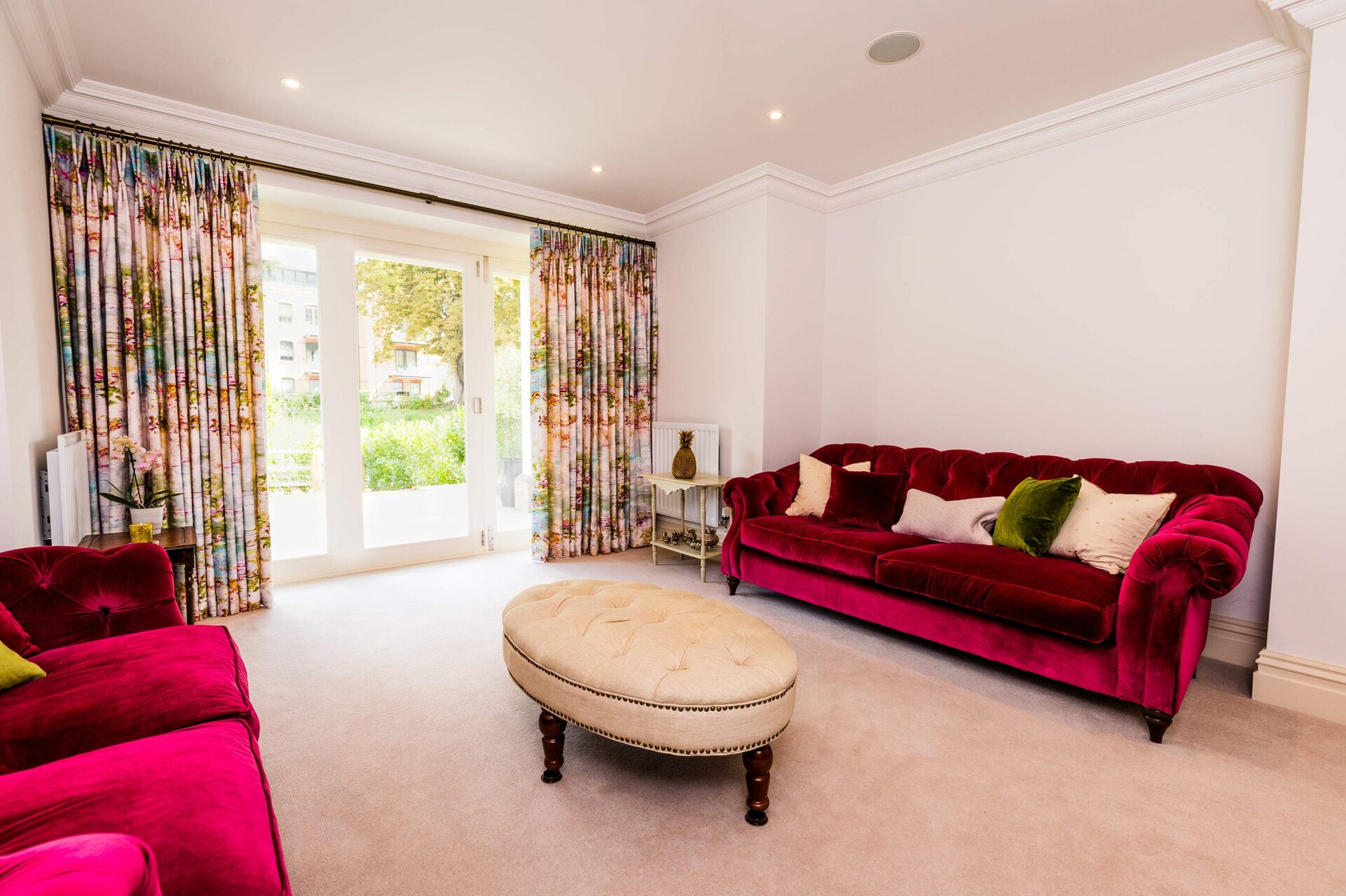 lounge with red sofas and made to measure curtains